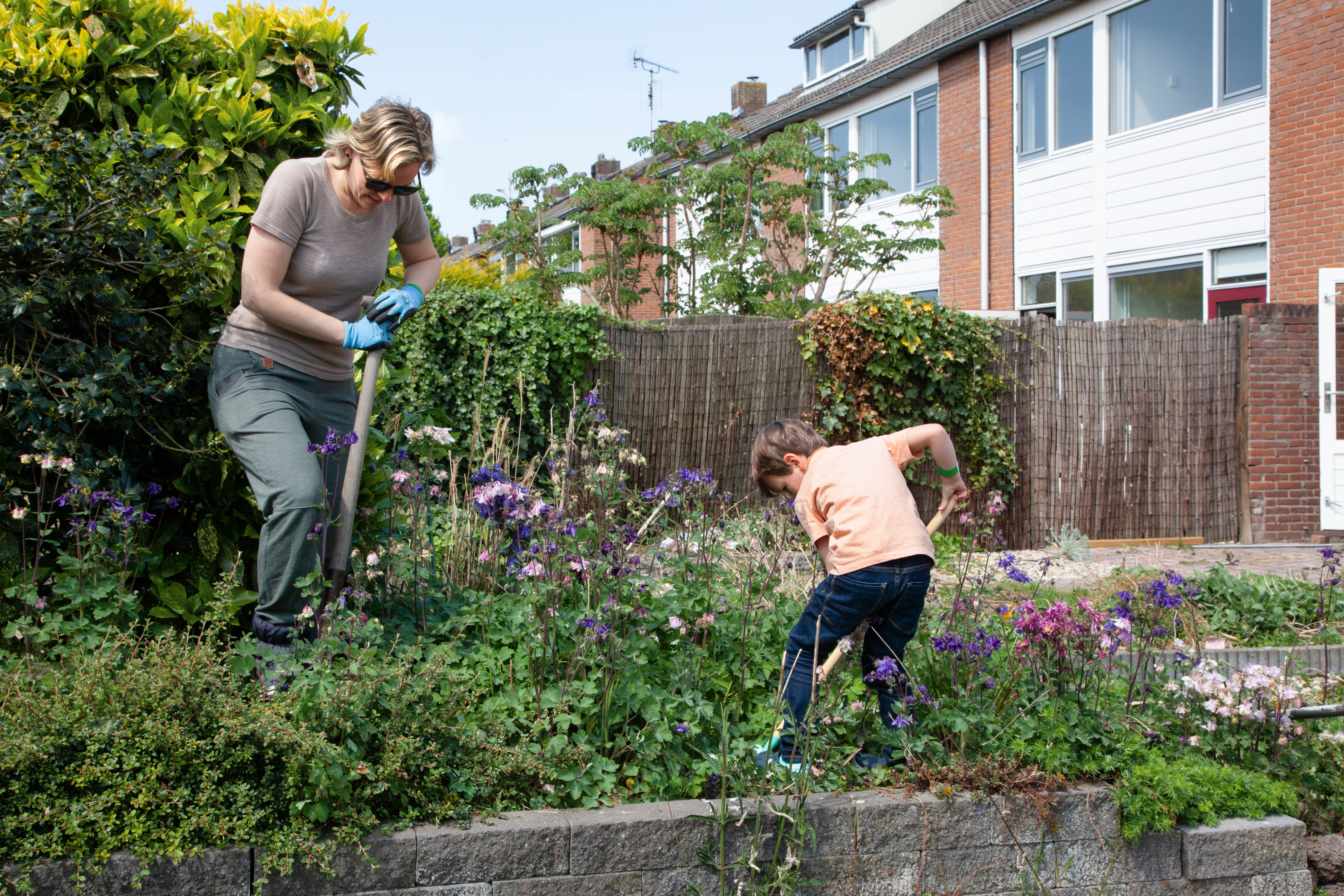 Foto van 2 mensen aan het werk in een tuin