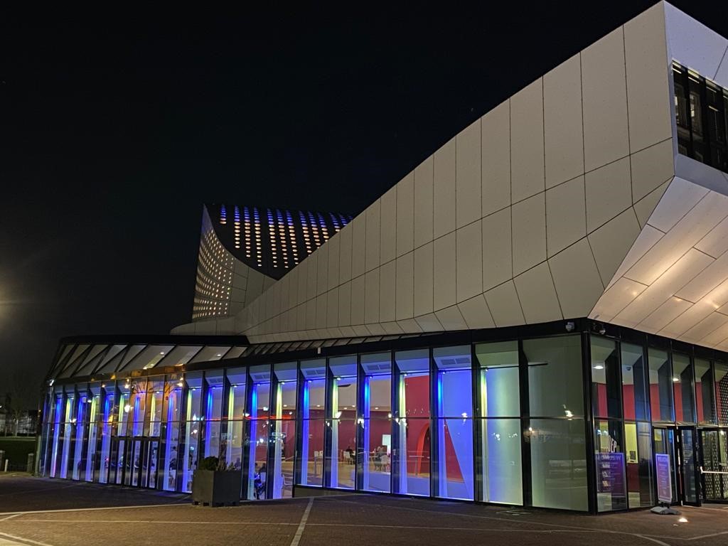 Foto van de gevel van Theater de Stoep met blauwe en gele verlichting